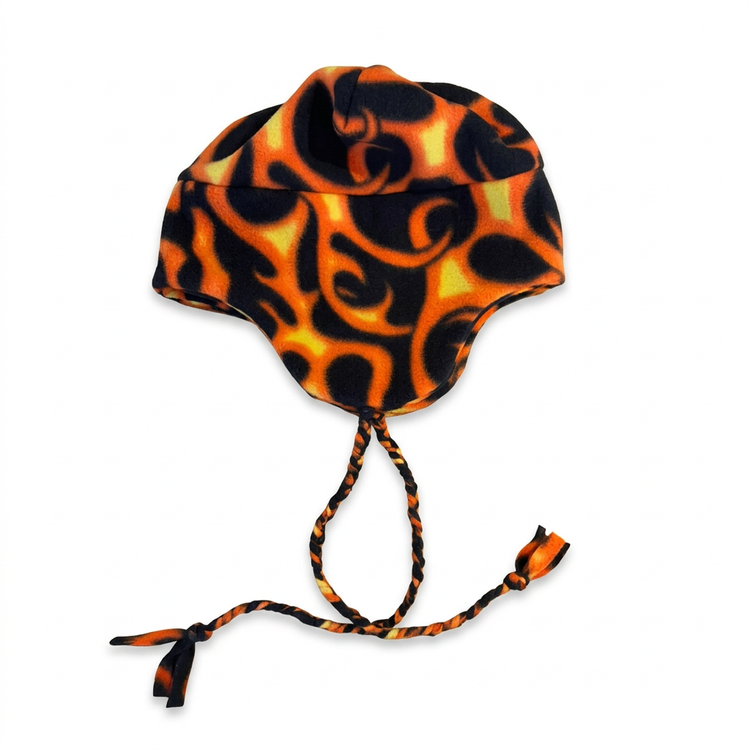 Black fleece ear flap hat with orange and yellow flames and braided ties on a plain white background